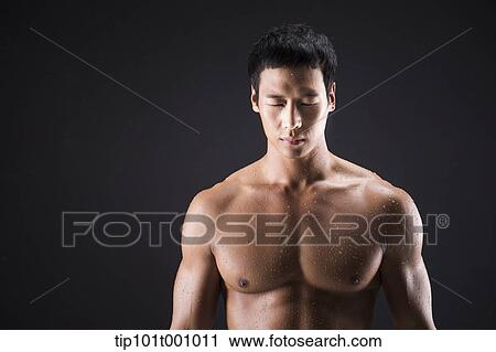 Stock Image - a fit man posing in black background. Fotosearch