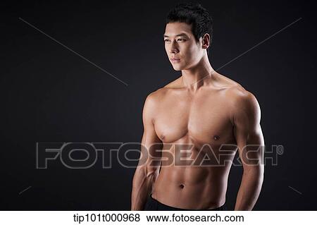 Stock Photo - a fit man posing in black background. Fotosearch