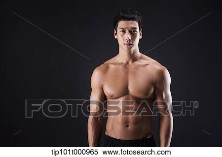 Stock Photography - a fit man posing in black background. Fotosearch
