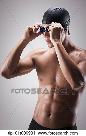 Stock Image - a fit man with swimming goggle and hat posing. Fotosearch