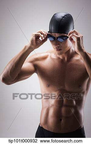 Stock Image - a fit man with swimming goggle and hat posing. Fotosearch