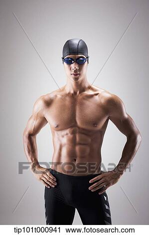Stock Image - a fit man with swimming goggle and hat posing. Fotosearch