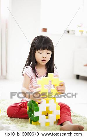 Stock Image - a girl building toy blocks. Fotosearch