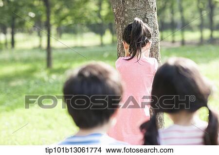 a girl counting against a tree View Large Photo Image Picture - a girl counting against a tree. Fotosearch