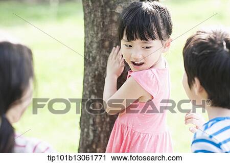 Stock Image - a girl counting against a tree. Fotosearch