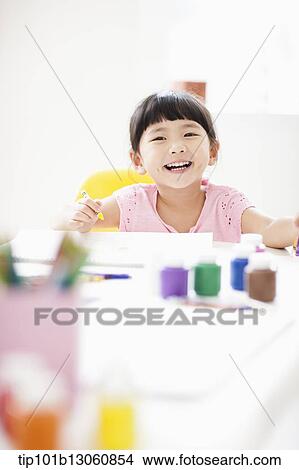a girl drawing on a sketch book with crayon View Large Photo Image Picture - a girl drawing on a sketch book with crayon. Fotosearch
