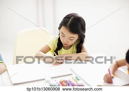 Stock Photo - a girl drawing on a sketch book with crayon. Fotosearch