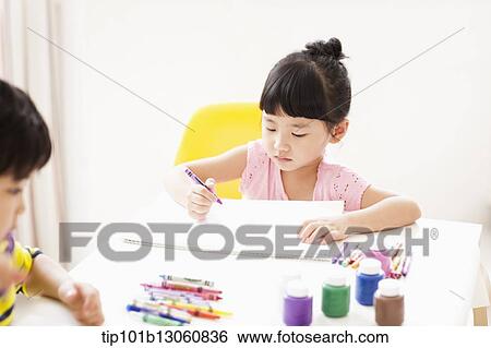 Stock Photograph - a girl drawing on a sketch book with crayon. Fotosearch