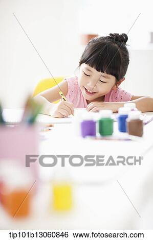Stock Photograph - a girl drawing on a sketch book with crayon. Fotosearch