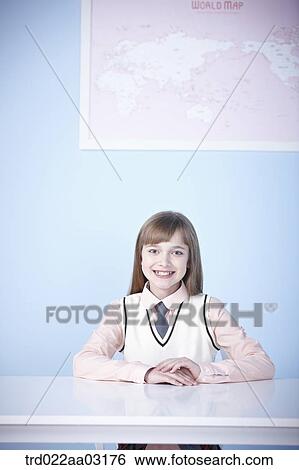 a girl dressed as a student sitting at a desk View Large Photo Image Stock Photograph - a girl dressed as a student sitting at a desk. Fotosearch