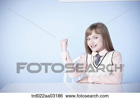 a girl dressed as a student sitting at a desk View Large Photo Image Stock Photograph - a girl dressed as a student sitting at a desk. Fotosearch
