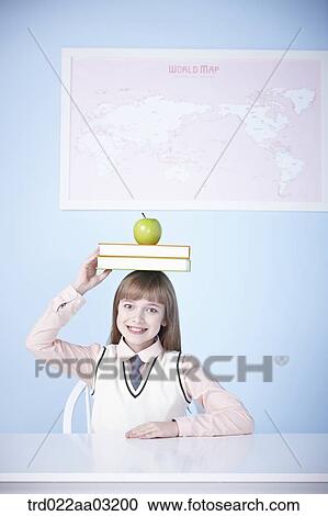a girl dressed as a student with books and an apple View Large Photo Image Stock Image - a girl dressed as a student with books and an apple. Fotosearch