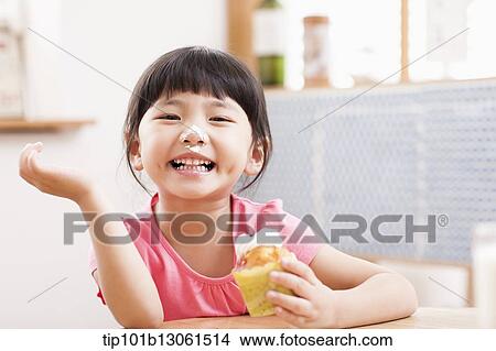 a girl eating a cupcake View Large Photo Image Picture - a girl eating a cupcake. Fotosearch