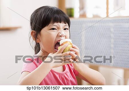 a girl eating a cupcake View Large Photo Image Stock Photo - a girl eating a cupcake. Fotosearch
