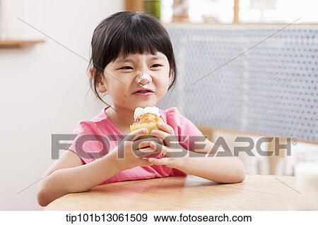 a girl eating a cupcake View Large Photo Image Stock Photo - a girl eating a cupcake. Fotosearch