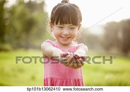 Stock Image - a girl holding a bunch of cherries. Fotosearch