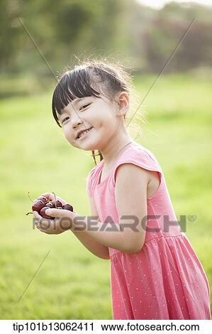 a girl holding a bunch of cherries View Large Photo Image Stock Image - a girl holding a bunch of cherries. Fotosearch