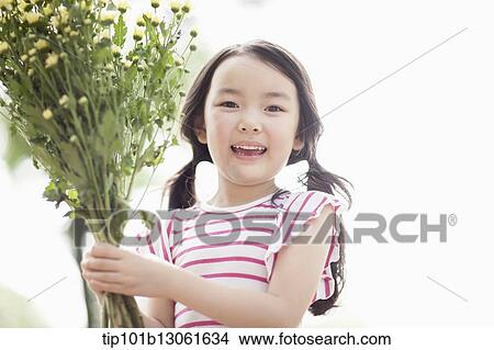 a girl holding a bunch of flowers View Large Photo Image Picture - a girl holding a bunch of flowers. Fotosearch