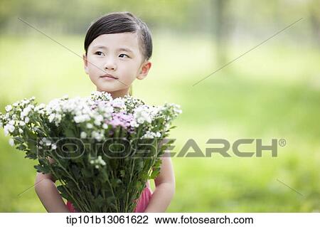 Stock Image - a girl holding a bunch of flowers. Fotosearch