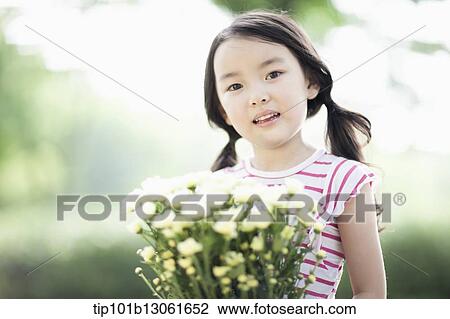 Stock Image - a girl holding a bunch of flowers. Fotosearch
