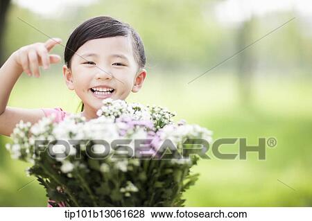 a girl holding a bunch of flowers View Large Photo Image Stock Photo - a girl holding a bunch of flowers. Fotosearch