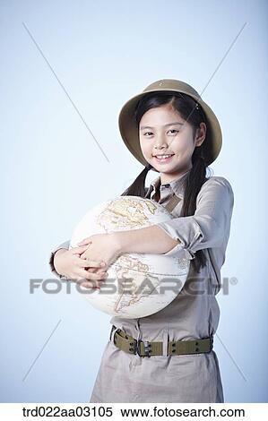 Stock Photography - a girl holding a globe dressed as an explorer. Fotosearch