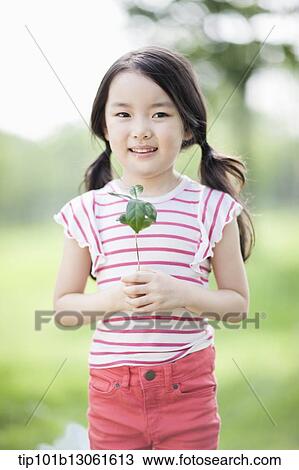 Stock Image - a girl holding a plant. Fotosearch