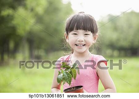 Stock Image - a girl holding a plant. Fotosearch