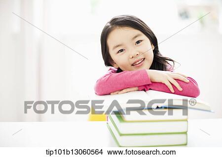 a girl leaning on a pile of books View Large Photo Image Picture - a girl leaning on a pile of books. Fotosearch