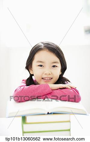 Stock Image - a girl leaning on a pile of books. Fotosearch
