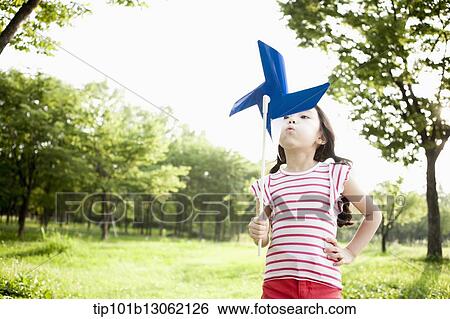 a girl playing with a toy wind mill View Large Photo Image Stock Photograph - a girl playing with a toy wind mill. Fotosearch