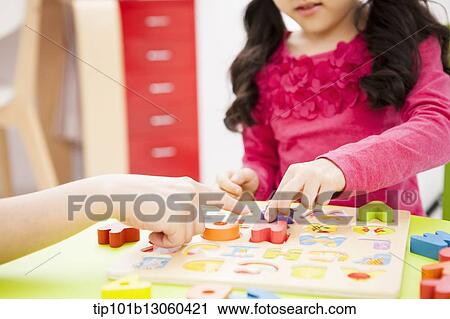 Stock Image - a girl playing with alphabet toys. Fotosearch