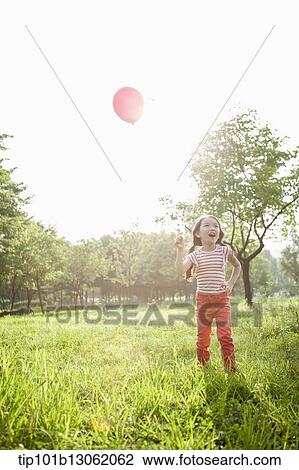 Stock Image - a girl playing with balloons. Fotosearch