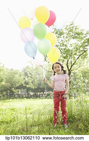 Stock Image - a girl playing with balloons. Fotosearch