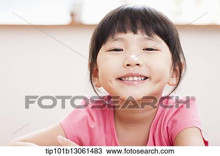 a girl sitting at a table smiling View Large Photo Image Stock Image - a girl sitting at a table smiling. Fotosearch