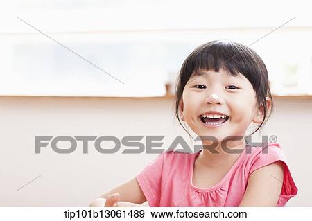 a girl sitting at a table smiling View Large Photo Image Stock Photo - a girl sitting at a table smiling. Fotosearch