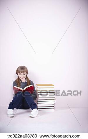 a girl with a book sitting next to a pile of books View Large Photo Image Stock Image - a girl with a book sitting next to a pile of books. Fotosearch