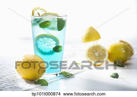 Picture - a glass of blue liquid with lemons. Fotosearch