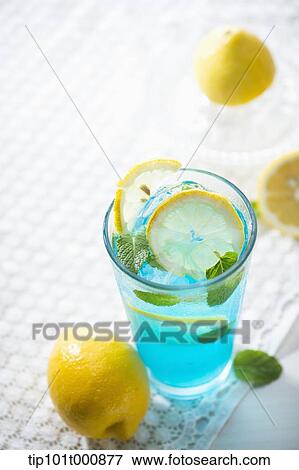 Stock Photo - a glass of blue liquid with lemons. Fotosearch