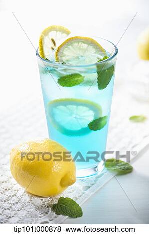 Stock Photo - a glass of blue liquid with lemons. Fotosearch