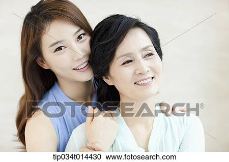 Stock Image - a grown up daughter hugging mother. Fotosearch