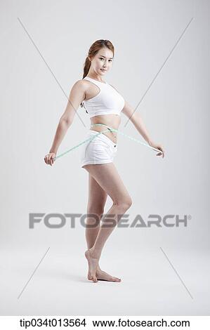 Picture - a healthy looking woman with measurement tape around the body. Fotosearch