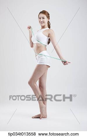 a healthy looking woman with measurement tape around the body View Large Photo Image Stock Photo - a healthy looking woman with measurement tape around the body. Fotosearch