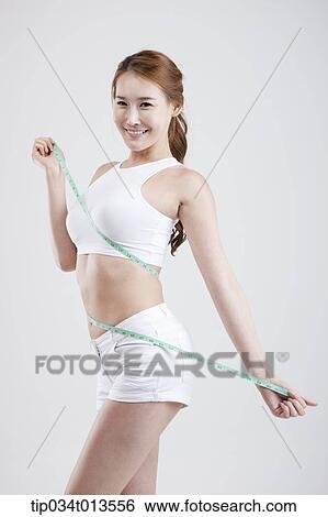 a healthy looking woman with measurement tape around the body View Large Photo Image Stock Photograph - a healthy looking woman with measurement tape around the body. Fotosearch