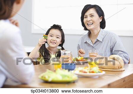 Stock Image - a kid and two women in the kitchen. Fotosearch