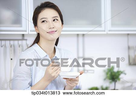 Stock Image - a kid and two women in the kitchen. Fotosearch