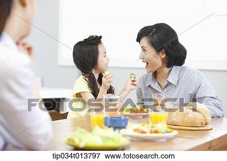 Stock Photo - a kid and two women in the kitchen. Fotosearch