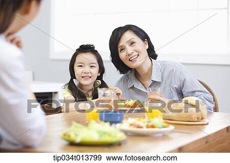 Stock Photo - a kid and two women in the kitchen. Fotosearch