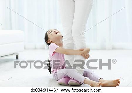 Stock Photo - a kid grabbing mother's legs. Fotosearch