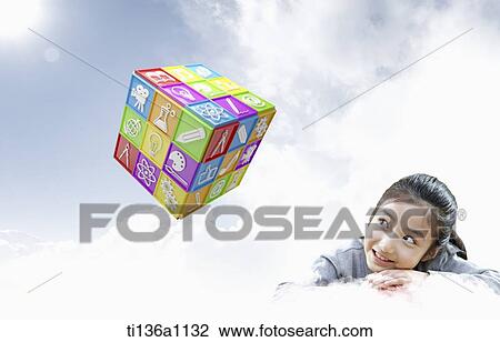 a kid leaning on her hands looking at cubic with icons View Large Photo Image Stock Image - a kid leaning on her hands looking at cubic with icons. Fotosearch